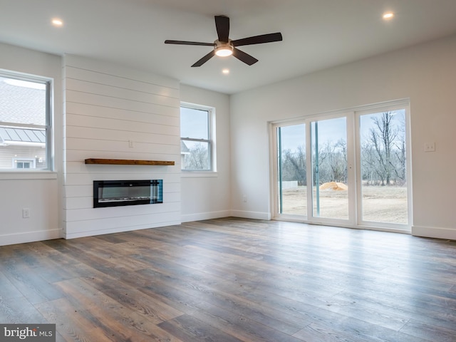 unfurnished living room featuring a ceiling fan, wood finished floors, recessed lighting, a fireplace, and baseboards