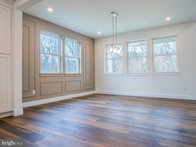 unfurnished dining area with dark wood finished floors, recessed lighting, and baseboards