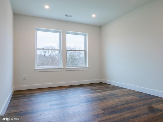 spare room with dark wood-style floors, visible vents, recessed lighting, and baseboards