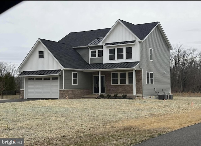 view of front of home featuring metal roof, stone siding, cooling unit, and a standing seam roof