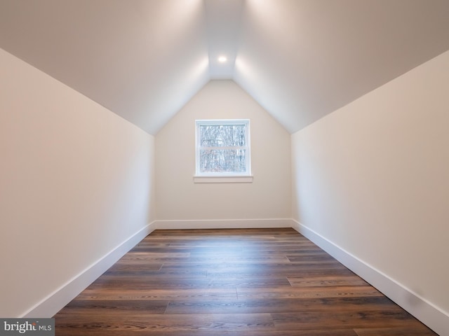 bonus room featuring baseboards, dark wood-type flooring, and lofted ceiling