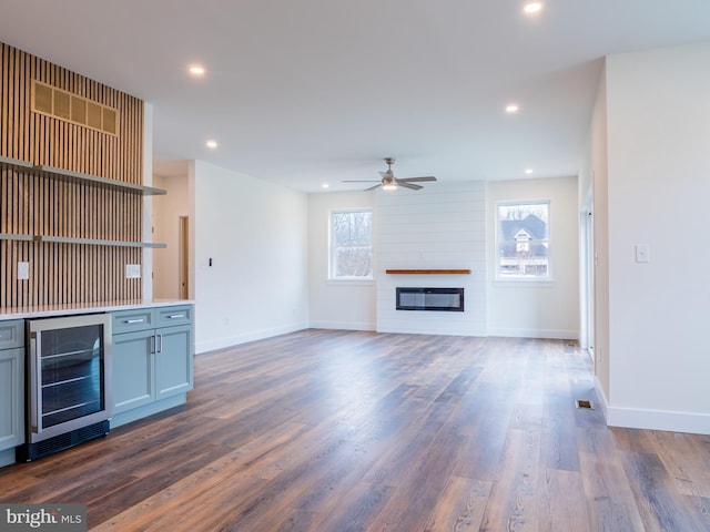 unfurnished living room with beverage cooler, recessed lighting, dark wood finished floors, and ceiling fan