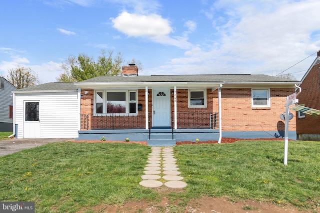 ranch-style home with a porch, a chimney, a front lawn, and brick siding