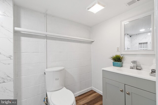 bathroom featuring vanity, baseboards, toilet, visible vents, and wood finished floors