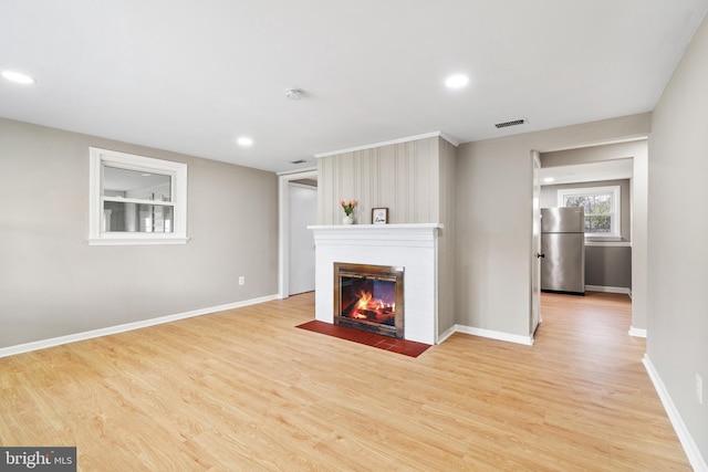 unfurnished living room with baseboards, recessed lighting, a fireplace, visible vents, and wood finished floors