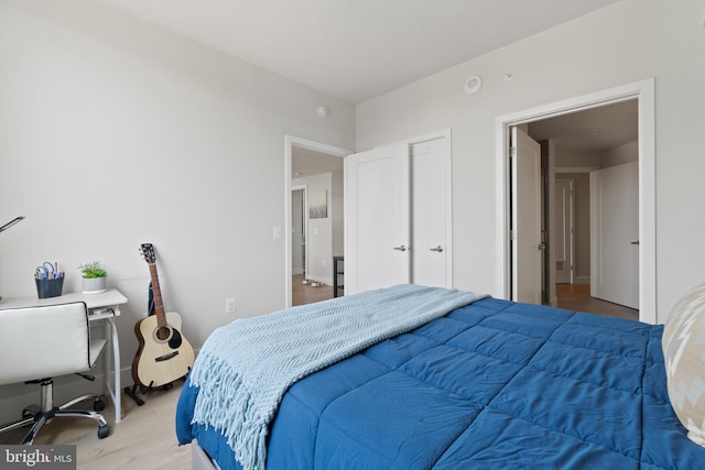 bedroom with light wood finished floors and baseboards