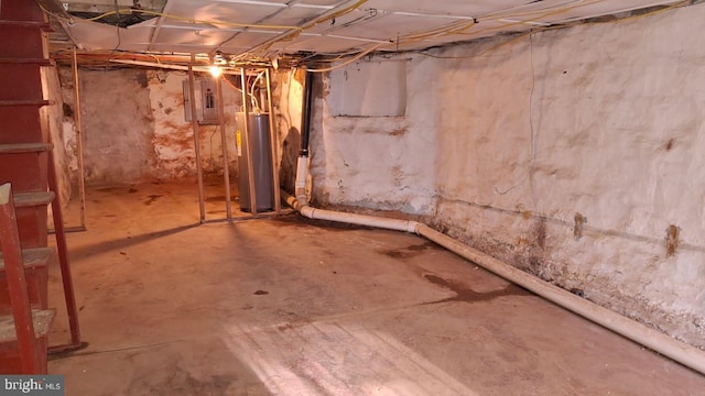 unfinished below grade area with electric panel and gas water heater