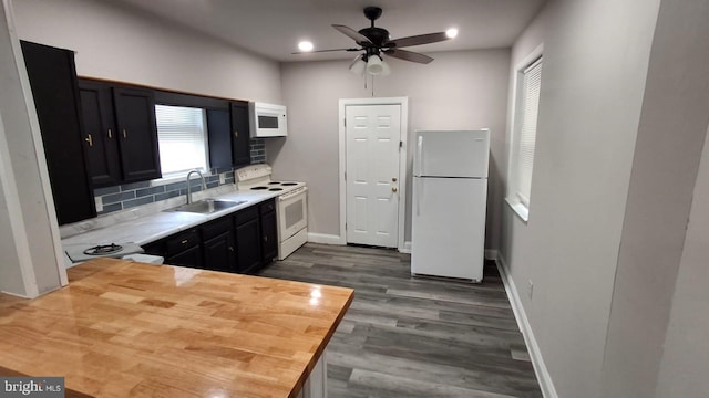 kitchen with backsplash, ceiling fan, dark wood finished floors, white appliances, and a sink