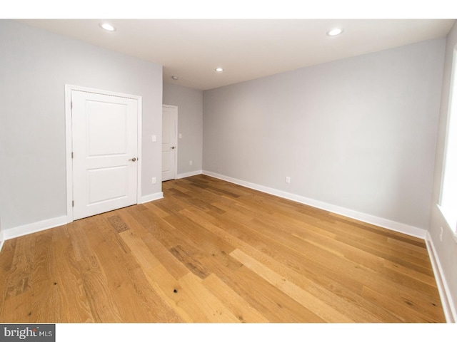 empty room with recessed lighting, baseboards, and light wood finished floors