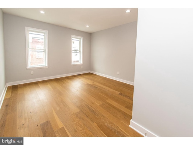 unfurnished room featuring recessed lighting, light wood-type flooring, and baseboards