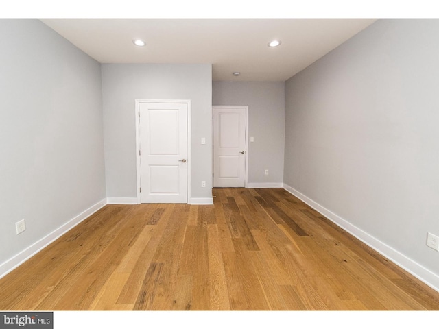 empty room with recessed lighting, light wood-style floors, and baseboards