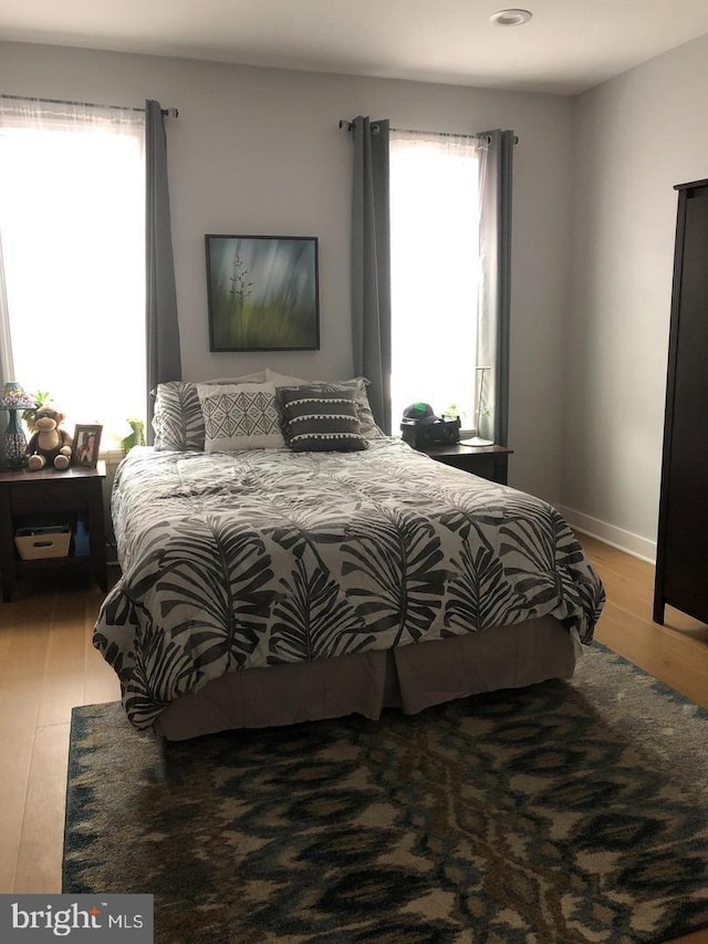 bedroom with baseboards and wood finished floors