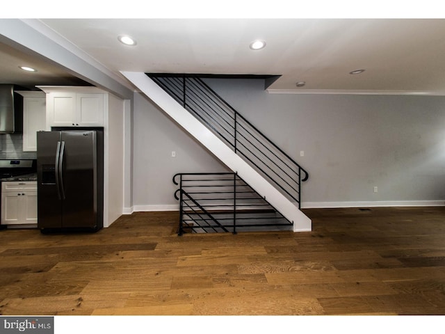 staircase featuring recessed lighting, crown molding, baseboards, and wood finished floors