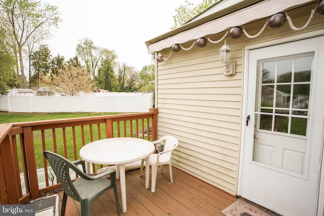 wooden deck with fence, a lawn, and outdoor dining area