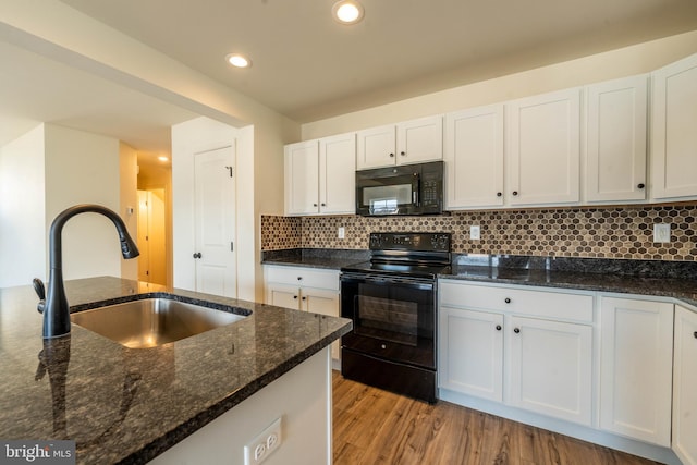 kitchen with white cabinets, black appliances, light wood-type flooring, and a sink