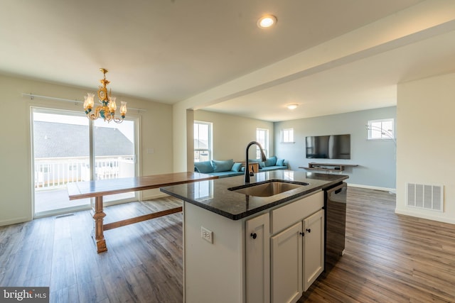 kitchen with visible vents, dark wood-style flooring, a sink, a notable chandelier, and open floor plan