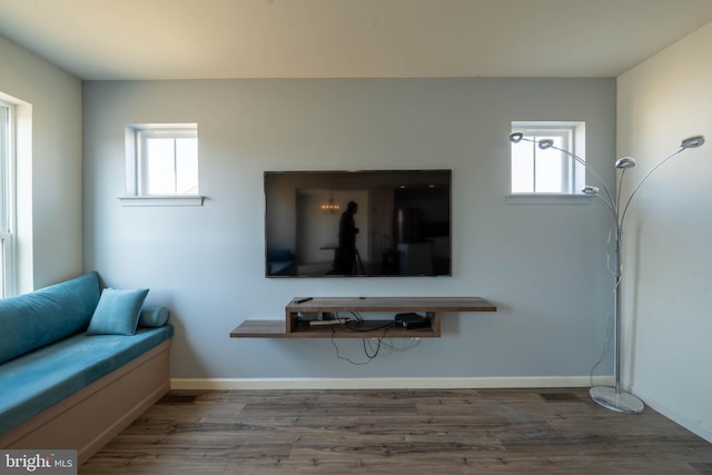 living area with visible vents, wood finished floors, and baseboards