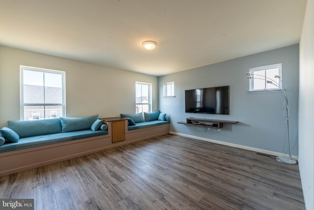 unfurnished living room with baseboards and wood finished floors