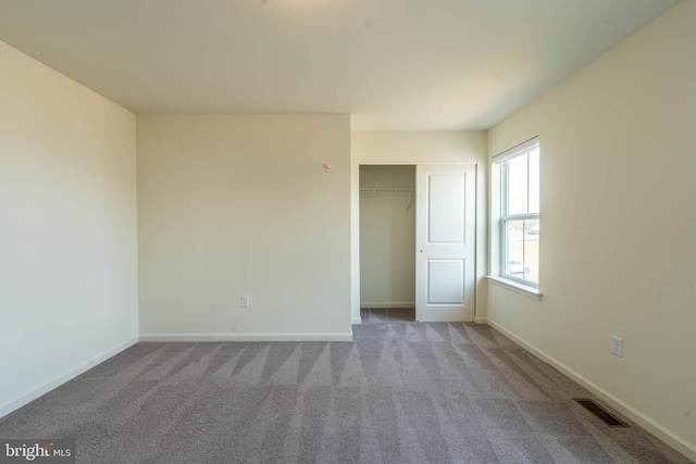 empty room with carpet, baseboards, and visible vents