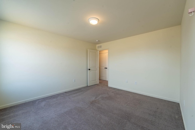 carpeted empty room featuring visible vents and baseboards