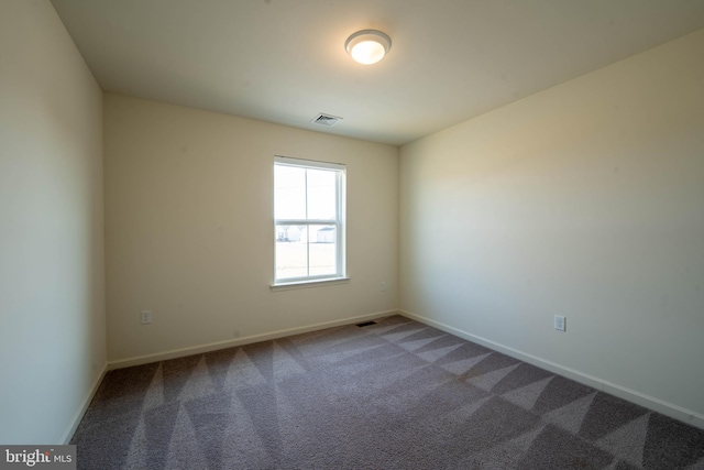 carpeted empty room featuring visible vents and baseboards