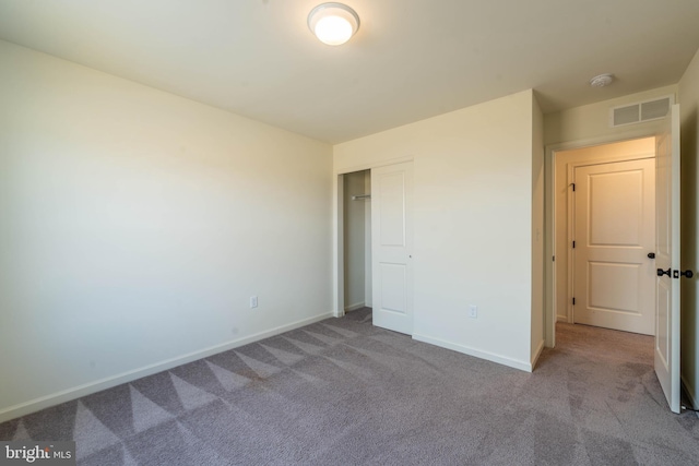 unfurnished bedroom with a closet, visible vents, baseboards, and carpet