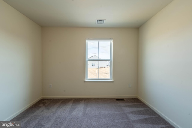 carpeted spare room with baseboards and visible vents