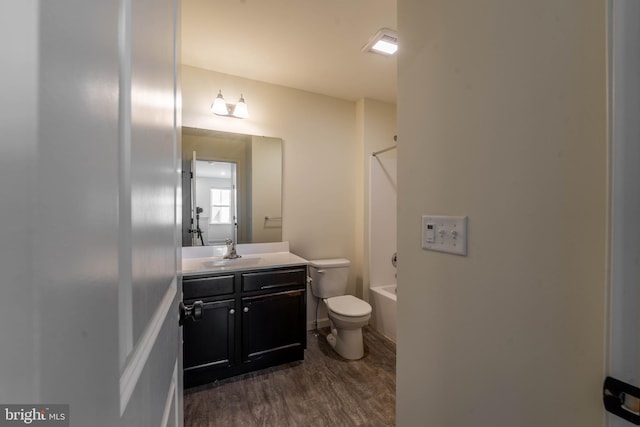 bathroom featuring vanity, toilet, wood finished floors, and shower / bath combination