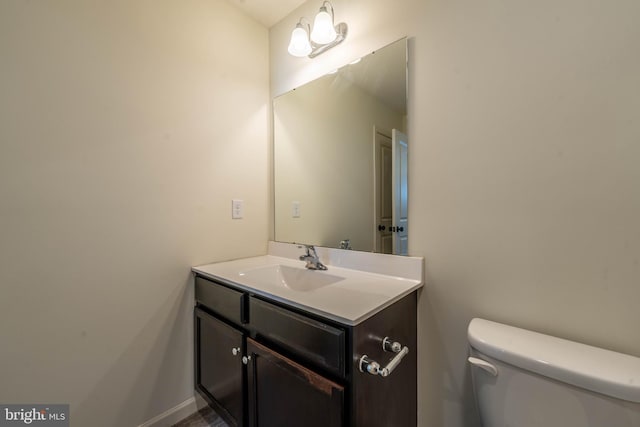 bathroom featuring baseboards, toilet, and vanity