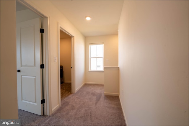 hall with baseboards and carpet floors