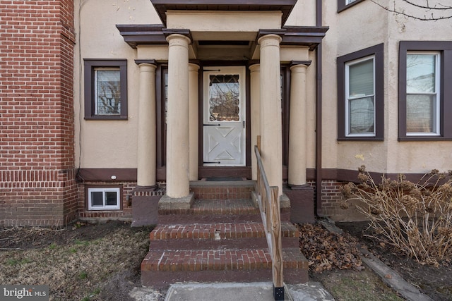 entrance to property featuring stucco siding