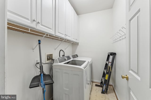 washroom with baseboards, light floors, cabinet space, and washer and clothes dryer