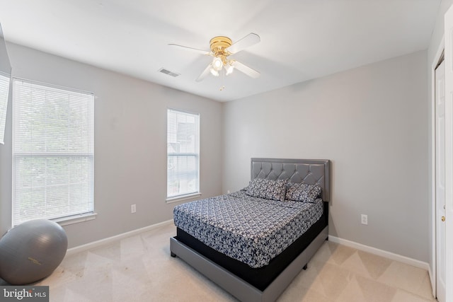 carpeted bedroom with baseboards, a ceiling fan, and visible vents