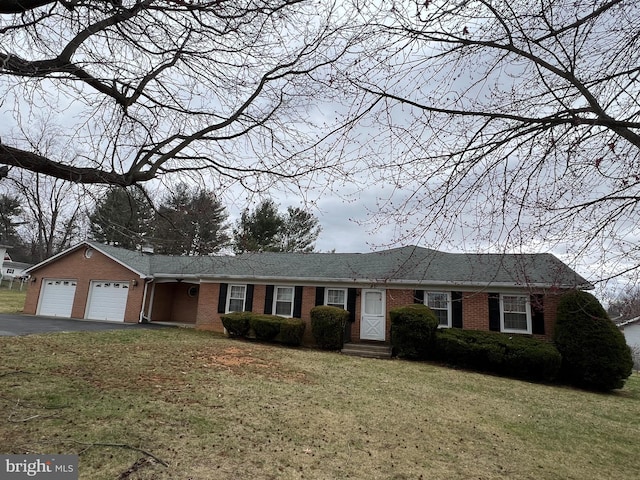 ranch-style home featuring a front yard, brick siding, a garage, and driveway