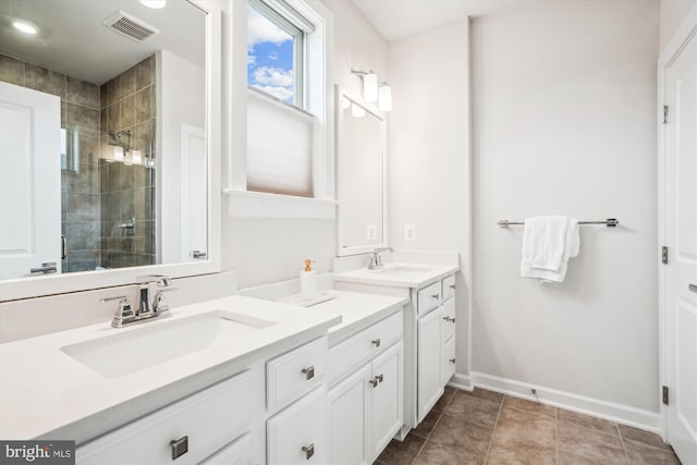 full bathroom with a sink, visible vents, double vanity, and a stall shower