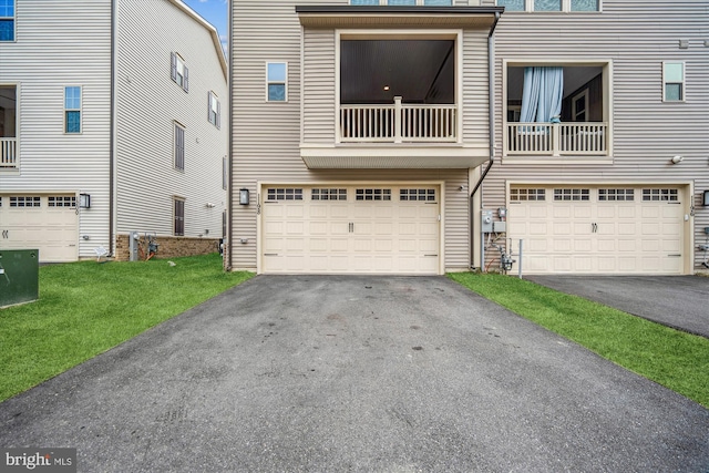 multi unit property with a front yard, a garage, and driveway