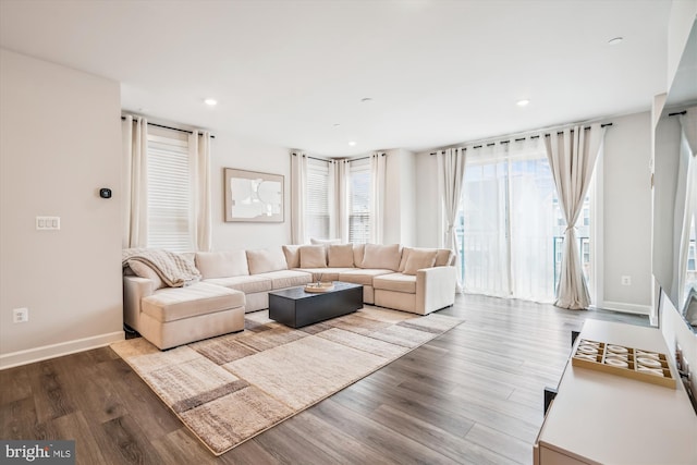 living area featuring baseboards, recessed lighting, and wood finished floors