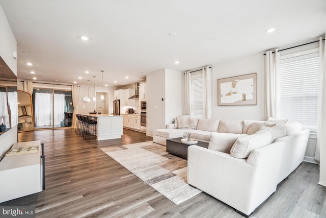 living area featuring a wealth of natural light, recessed lighting, and light wood-style flooring