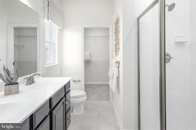 full bathroom featuring a walk in closet, toilet, a sink, a shower stall, and double vanity