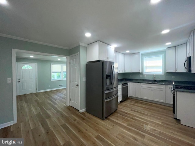 3801 Parkside Dr, Baltimore, MD 21206 - kitchen with white cabinetry, dark countertops, light wood-style floors, and appliances with stainless steel finishes