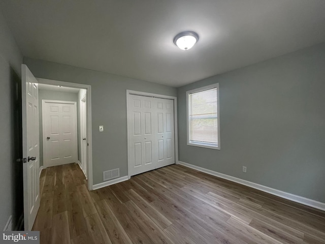 3801 Parkside Dr, Baltimore, MD 21206 - unfurnished bedroom featuring baseboards, visible vents, a closet, and wood finished floors