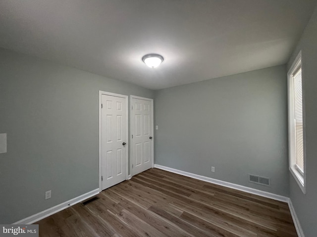 3801 Parkside Dr, Baltimore, MD 21206 - unfurnished bedroom with baseboards, dark wood-style flooring, and visible vents
