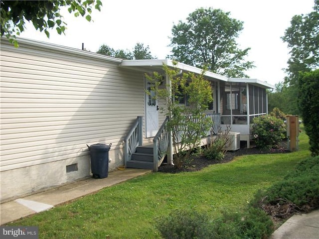 exterior space featuring crawl space, central AC, a yard, and a sunroom