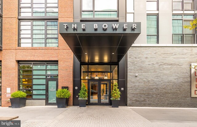 entrance to property featuring french doors and brick siding