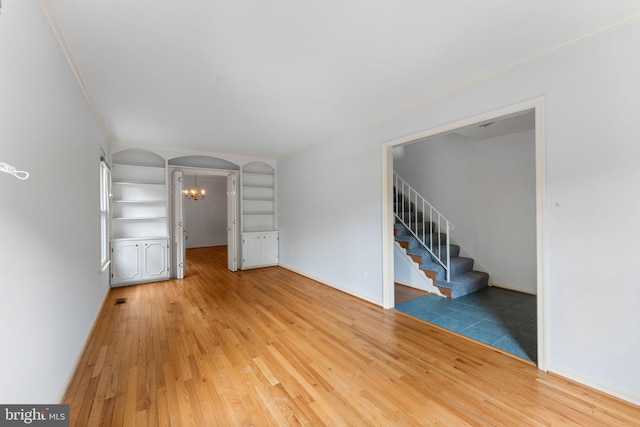 22 E Howell Ave, Alexandria, VA 22301 - unfurnished living room featuring arched walkways, light wood-style flooring, stairway, a chandelier, and ornamental molding