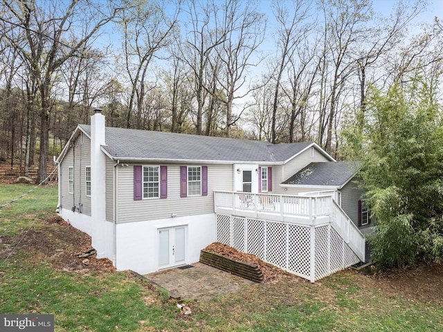 back of house with a chimney and a deck