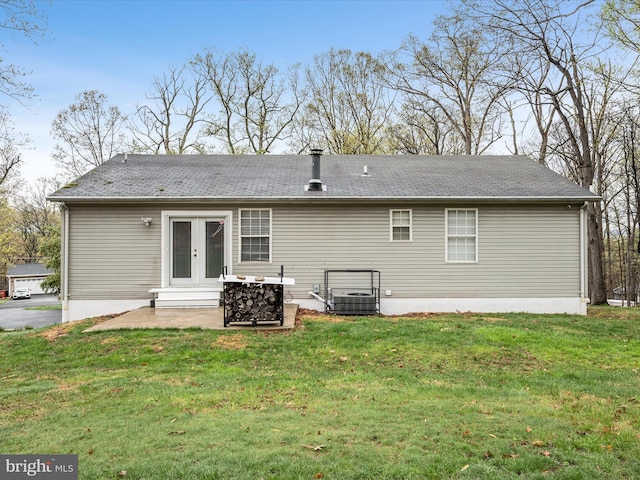 rear view of house with french doors, a patio, and a yard
