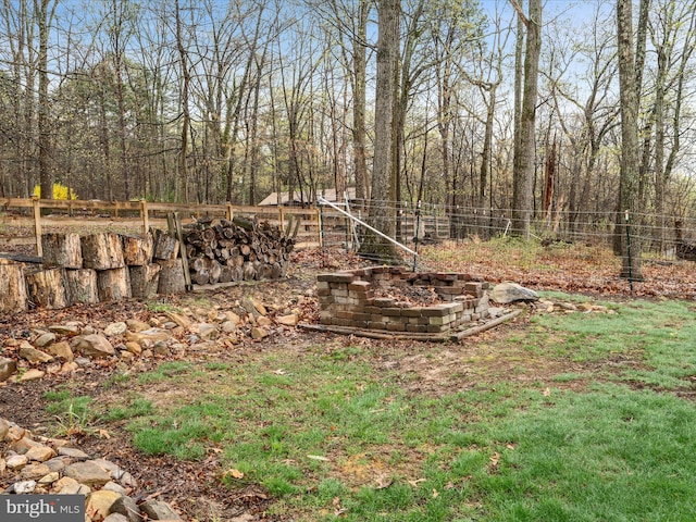 view of yard with a fire pit and fence