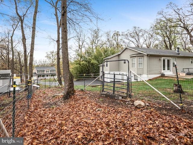 exterior space featuring french doors, a chimney, fence private yard, and a gate