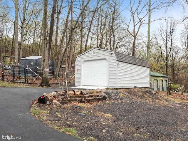 detached garage with fence and driveway
